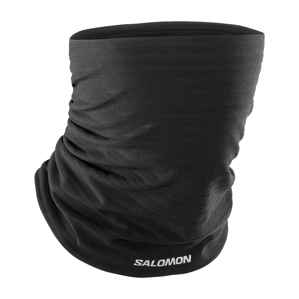 Et enkelt, sort halsrør i strækbart, let materiale med synligt hvidt Salomon-logo i nederkanten. Stoffet ligger tæt og rynket for at vise fleksibilitet og åndbarhed, og designet er sømløst og minimalistisk. Produktet virker alsidigt til løb, skiløb og udendørsaktiviteter, hvor det beskytter mod vind og kulde samtidig med, at det kan bruges som halsedisse, pandebånd eller hue.