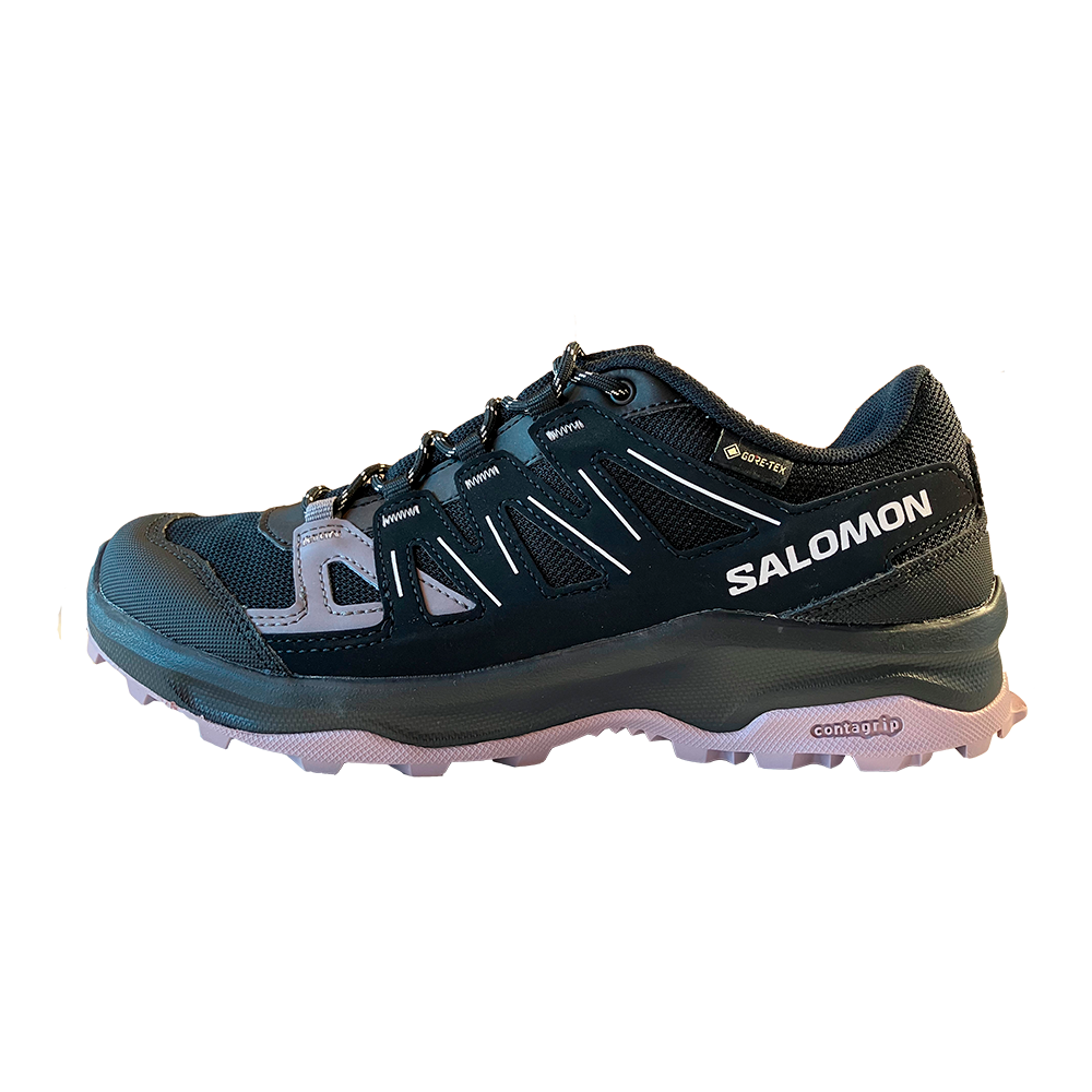 Et robust Salomon trail-sneaker i sort med lyserød sål, designet til udendørs brug. Skoens mesh- og syntetiske overdel kombinerer åndbarhed og støtte, mens Gore‑Tex-mærket indikerer vandtæt beskyttelse. Forstærket tåområde, sikrede snørebånd og mellemsål giver komfort og stabilitet. Contagrip-ydersålen sikrer godt greb på ujævne stier, hvilket gør skoen velegnet til både vandring og aktiv fritid.