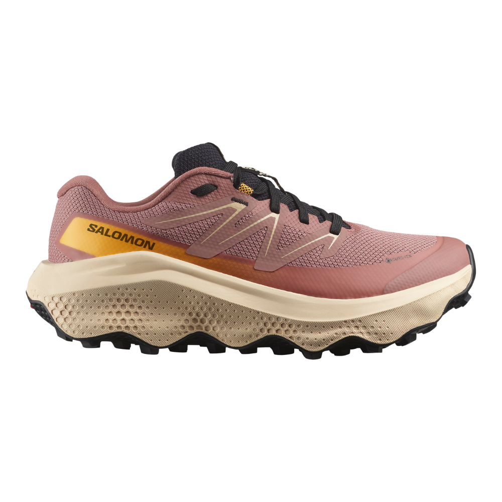 orange ved hælen, aggressivt mønster i sålen for godt greb og en polstret hælkappe, som signalerer komfort og stabilitet til trail- eller langtursløb.