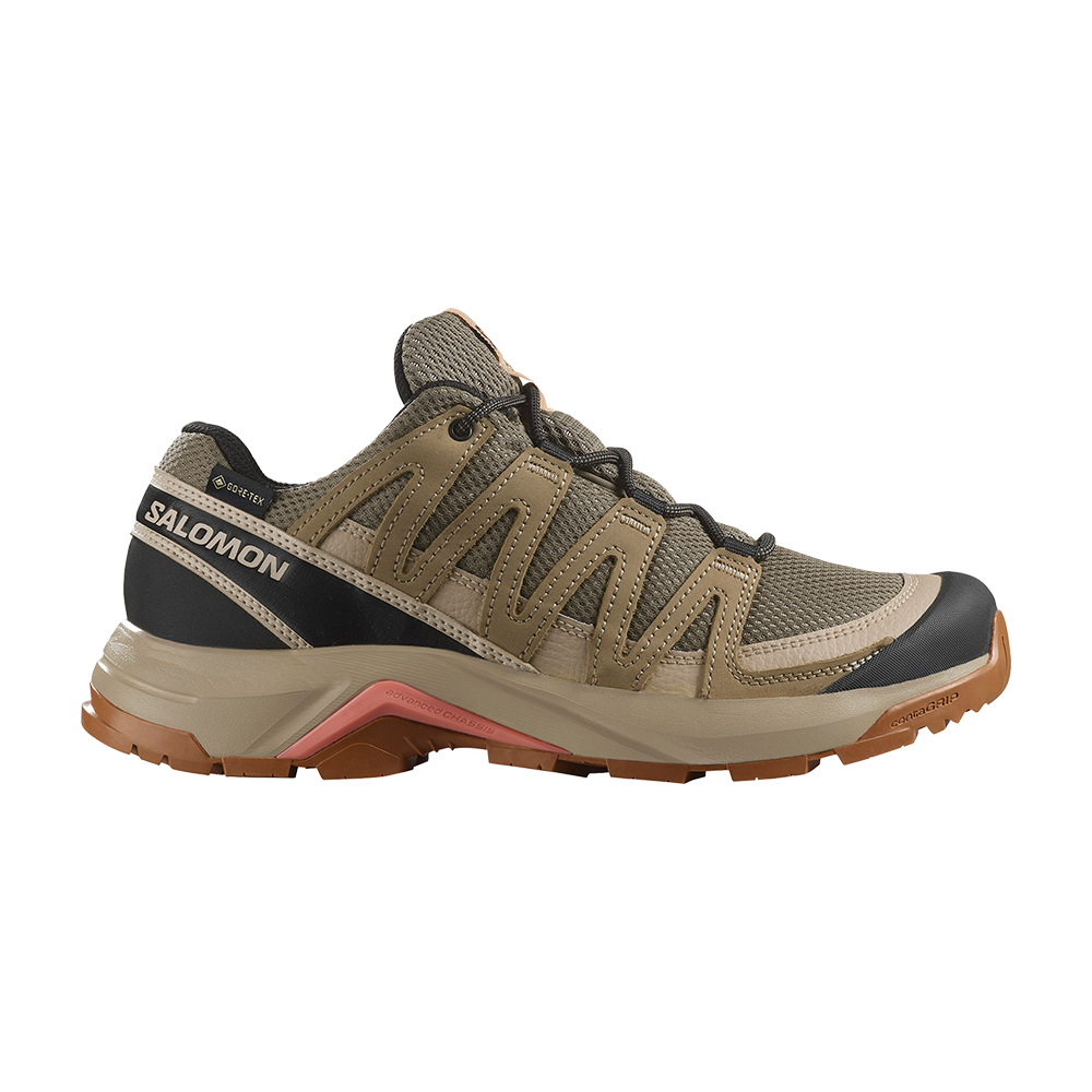 Et robust Salomon vandresko i afdæmpede jordfarver med brunbeige mesh og slidstærke syntetiske forstærkninger. Skoen har sort hælkappe, GORE-TEX-label, beskyttende forfod og Contagrip-gummisål med dybt mønster for greb på ujævnt terræn. Polstret krave og tætsiddende snøresystem sikrer stabilitet og komfort til lange ture i skoven eller på grusstier. Et funktionelt design fokuseret på holdbarhed og vejrligssikring.
