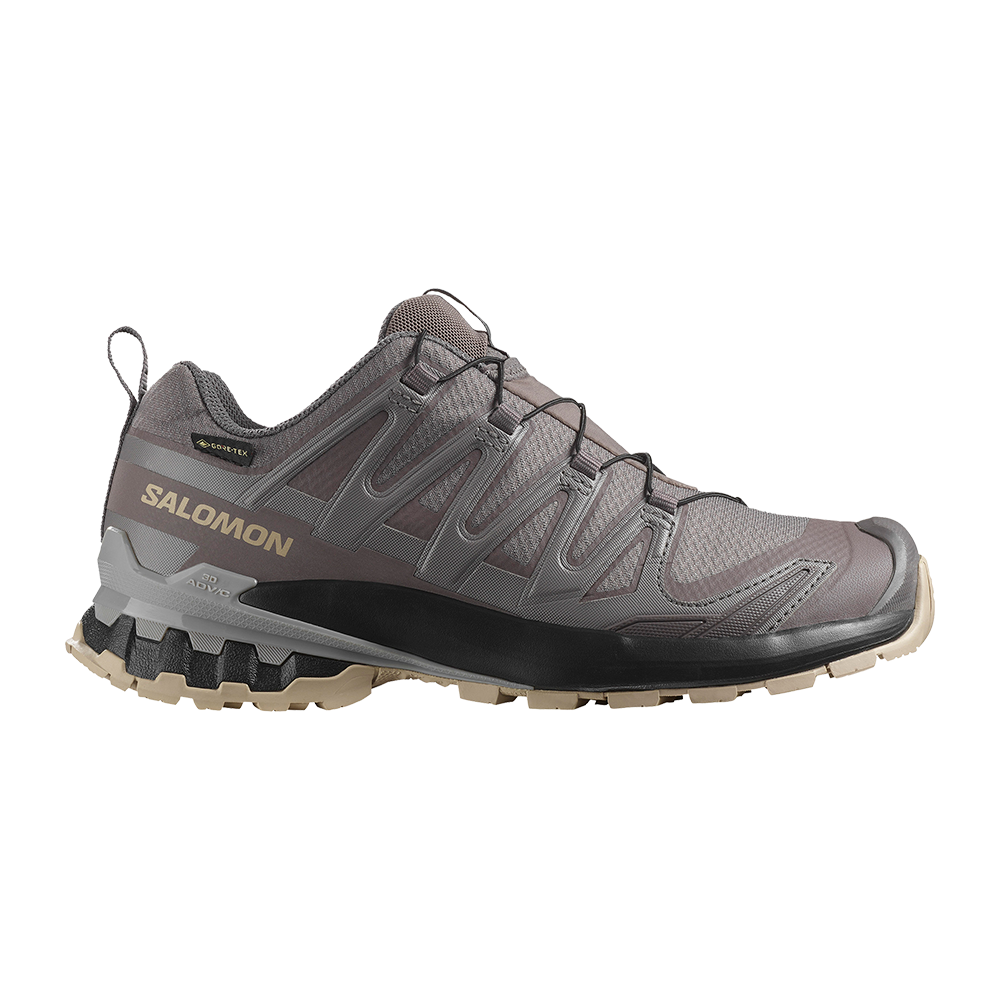 Dette er en robust Salomon vandresko i dæmpede grå- og brune nuancer med tydelig Salomon-logo og GORE-TEX-mærke. Skoen har et lavt snit, holdbar overdel og et avanceret snøresystem for sikker pasform. Den aggressive, multidirektionelle ydersål og polstrede mellemsål giver greb og stødabsorbering på ujævnt terræn. Velegnet til lange ture i vådt og kuperet terræn.