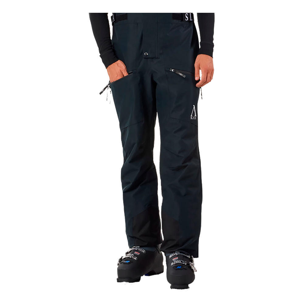 På billedet vises en ung mand iført Slade Aspen Bib Pants, som er skibukser designet til herrer. Bukserne er mørkeblå med justerbare hvide seler, der har Slade-logoet. Det funktionelle design tilbyder flere lommer, der er strategisk placeret for nem adgang. Disse skibukser ser både stilfulde og praktiske ud, ideelle til ski-entusiaster, der ønsker kvalitet og funktionalitet på skibakkerne. Bukserne fremhæver et moderne look med deres stramme linjer og robuste materialer.