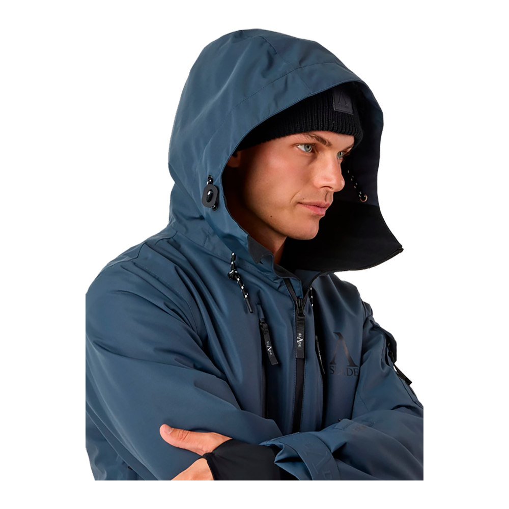 Billedet viser en mand iført Slade Aspen Jacket II Sr, en højteknologisk vinter- og skijakke. Jakken, som er i en mørkeblå nuance, er designet til aktiv brug i koldt klima og har detaljer som tapede sømme, vandtætte lynlåse, og en fast justerbar hætte. Funktionerne inkluderer varm Sorona Aura-isolering og miljøvenlig PFC-fri overfladebehandling. Dens mange lommer sikrer praktisk opbevaring, hvilket gør jakken ideel til både sport og hverdag.