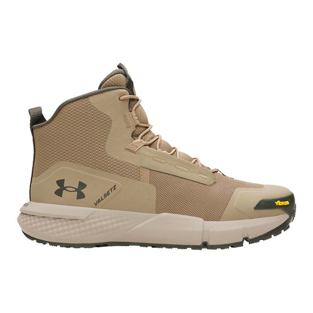 Billedet viser en høj snørestøvle i sandfarver fra Under Armour. Designet kombinerer åndbart mesh og robust syntetisk materiale med forstærkede paneler ved tå og hæl. Det polstrede skaft og den stabile mellemsål giver god støtte, mens Vibram-yddersålen leverer greb på ujævnt terræn. Et stilrent, funktionelt valg til vandring og urban outdoor. Perfekt til lange dage i naturen.