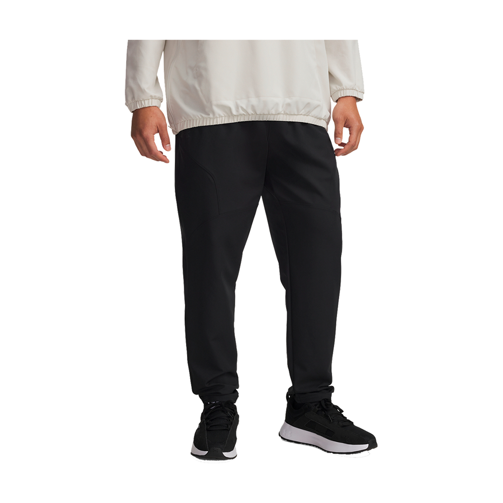 En stilren, sporty fremstilling af mørke joggers i sort teknisk stof, med markerede sømme og rummelige lommer. Bukserne har en moderat, afslappet pasform med elastisk talje og smalle, elastiske ankler, der fremhæver løbeskoene. Sammen med en lys vindjakke og sorte sneakers med hvide såler skabes et moderne, funktionelt look velegnet til træning eller hverdag.