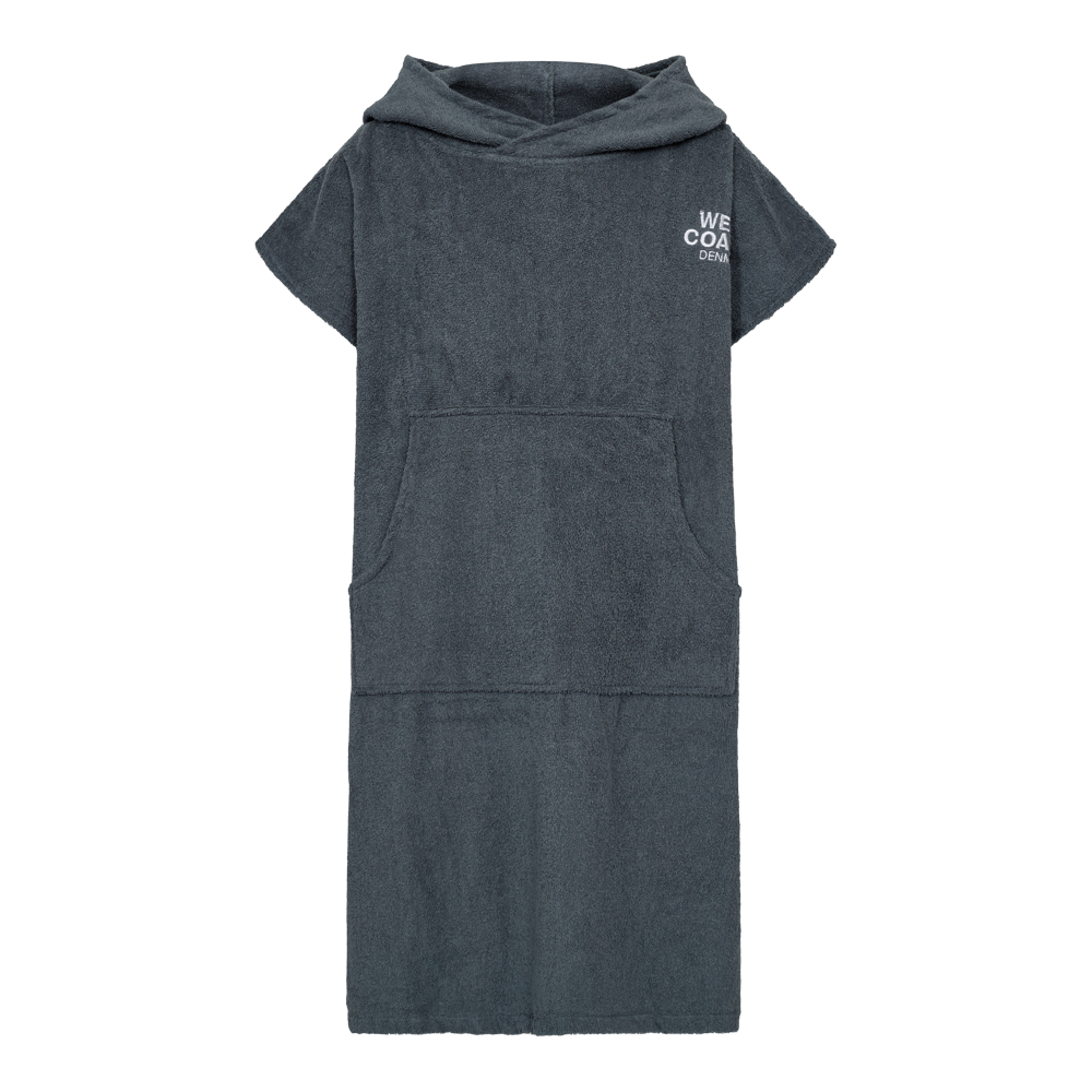 En mørkegrå hætteponcho i blød frotté, vist på en mannequin. Kjortellignende og med korte ærmer, stor kængurulomme foran og en rummelig hætte, der giver ekstra varme efter bad. Enkel hvid tekst ved brystet bryder det rolige udtryk. Praktisk og afslappet design, velegnet til strand, pool eller som hyggeligt omslag hjemme. Materialet føles absorberende og hurtigtørrende.
