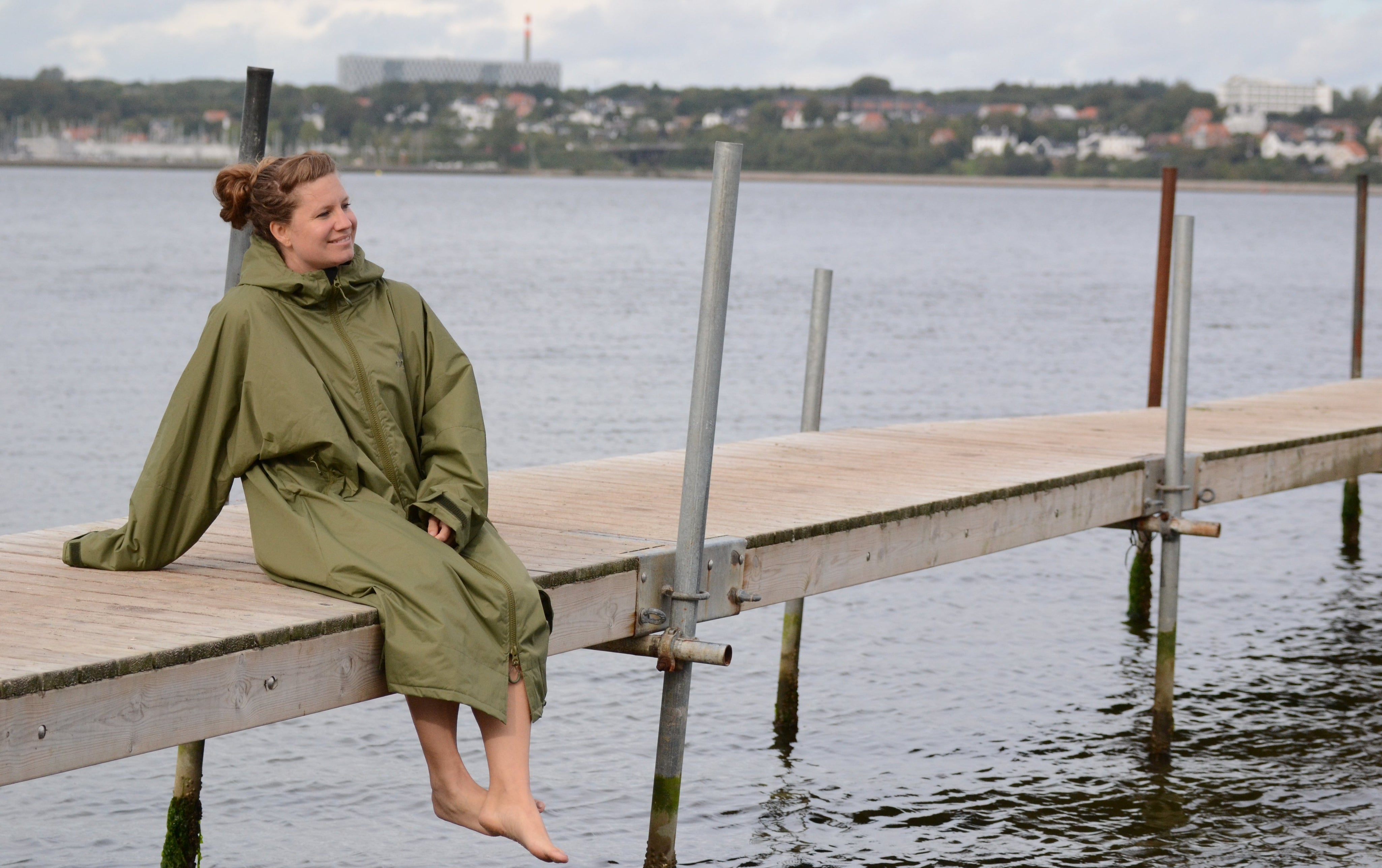 Dame iført grøn Beach Robe siddende på en badebro