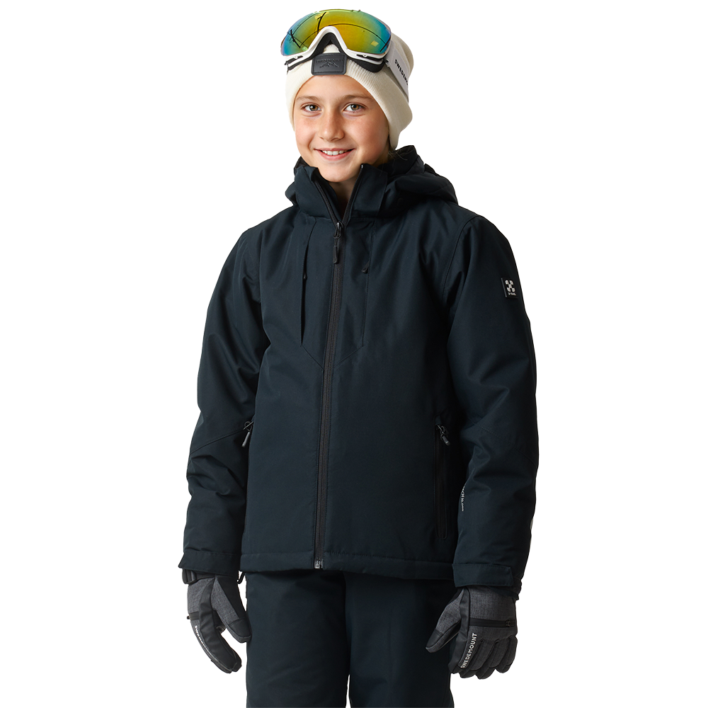 Et billede af et smilende barn iført komplet skitøj: en mørk, vandtæt jakke med hætte, matchende bukser og forede handsker. På hovedet sidder en lys hue med et par skibriller løftet op over panden. Baggrunden er neutral, hvilket fremhæver det praktiske, varme outfit til vinteraktiviteter og det afslappede, glade udtryk i ansigtet.