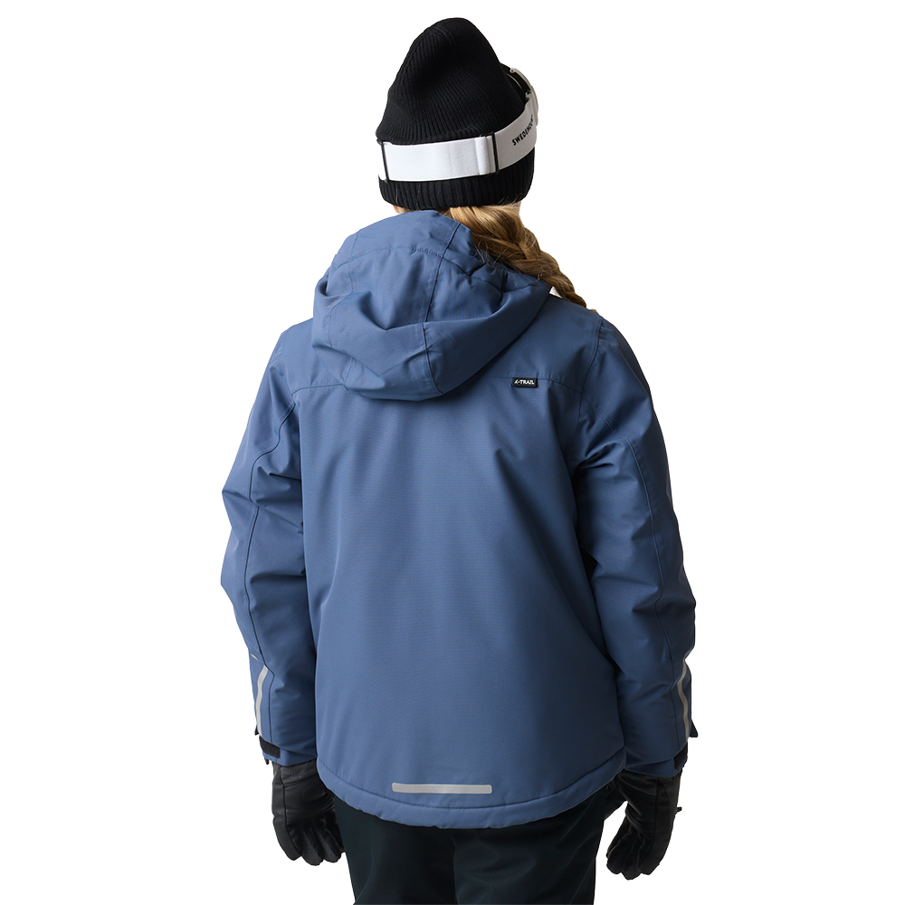 En bagfraoptagelse af en person iklædt en blå, vandafvisende vinterjakke med hætte. Personen har en sort strikhue med en hvid justerbar rem til skibriller og langt hår i fletning, samt sorte handsker. Jakken har synlige sømme, let fyld og reflekterende detaljer nederst og på ærmerne, hvilket signalerer funktionel, varm og sikker beklædning til udendørs vinteraktiviteter.