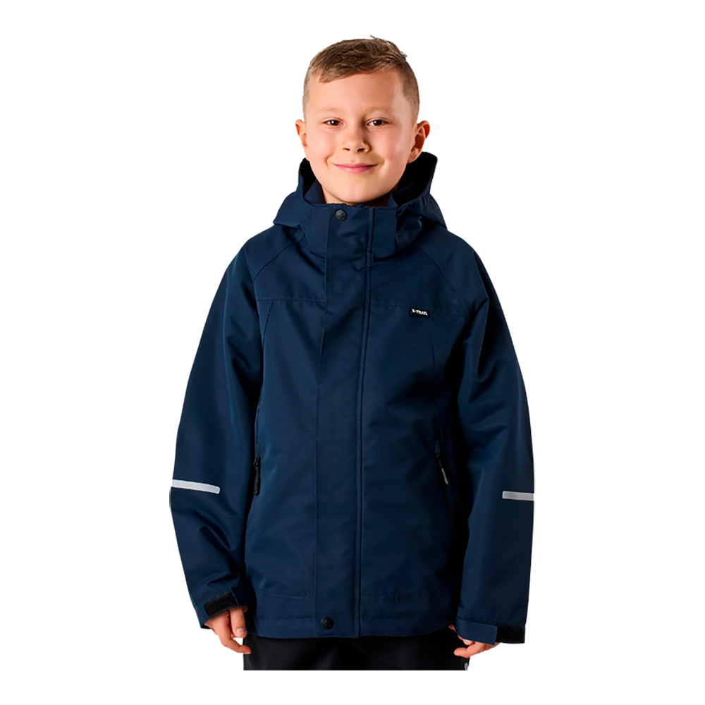 Et smilende barn står iført en mørkeblå, vind- og vandtæt jakke med hætte. Jakken har praktiske lynlåslommer og reflekterende striber på ærmerne samt velcrolukning ved håndleddene. Barnet ser afslappet og trygt ud, med kort, lysebrunt hår og en neutral baggrund, der fremhæver overtøjet. Billedet giver et indtryk af funktionelt, hverdagsligt yderbeklædning til børn.