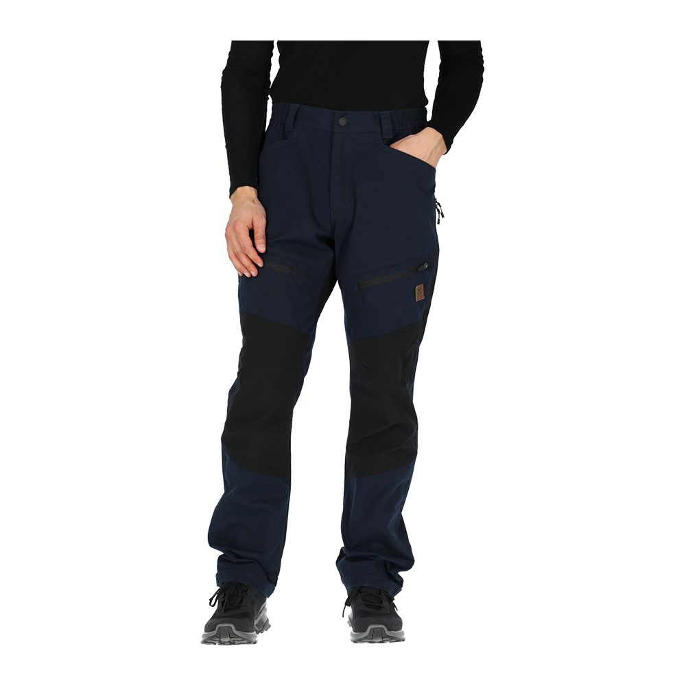 Et par robuste, tofarvede bukser i mørkeblå og sort ses på billedet. Bukserne har forstærkede knæpartier, lynlåslommer på lårene og praktiske sidelommer, hvilket giver et funktionelt udtryk. Modellen står afslappet med hænder i lommerne og bærer sorte vandresko. Materialet virker slidstærkt og velegnet til arbejde eller udendørsaktiviteter, med en løs pasform der giver bevægelsesfrihed.