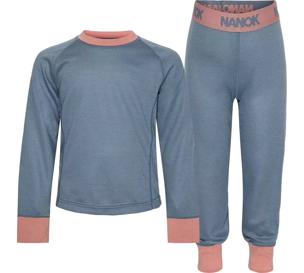leggings i støvet blå med lyserøde kantdetaljer ved hals, manchetter og talje. Ribbede linninger, tætsiddende snit og elastisk linning med "NANOK"-tryk. Materialet ser ud til at være varmt og strækbart, velegnet som baselag til udendørsaktiviteter i koldt vejr. Enkel, funktionel og komfortabel stil til børn. Let at bevæge sig i.