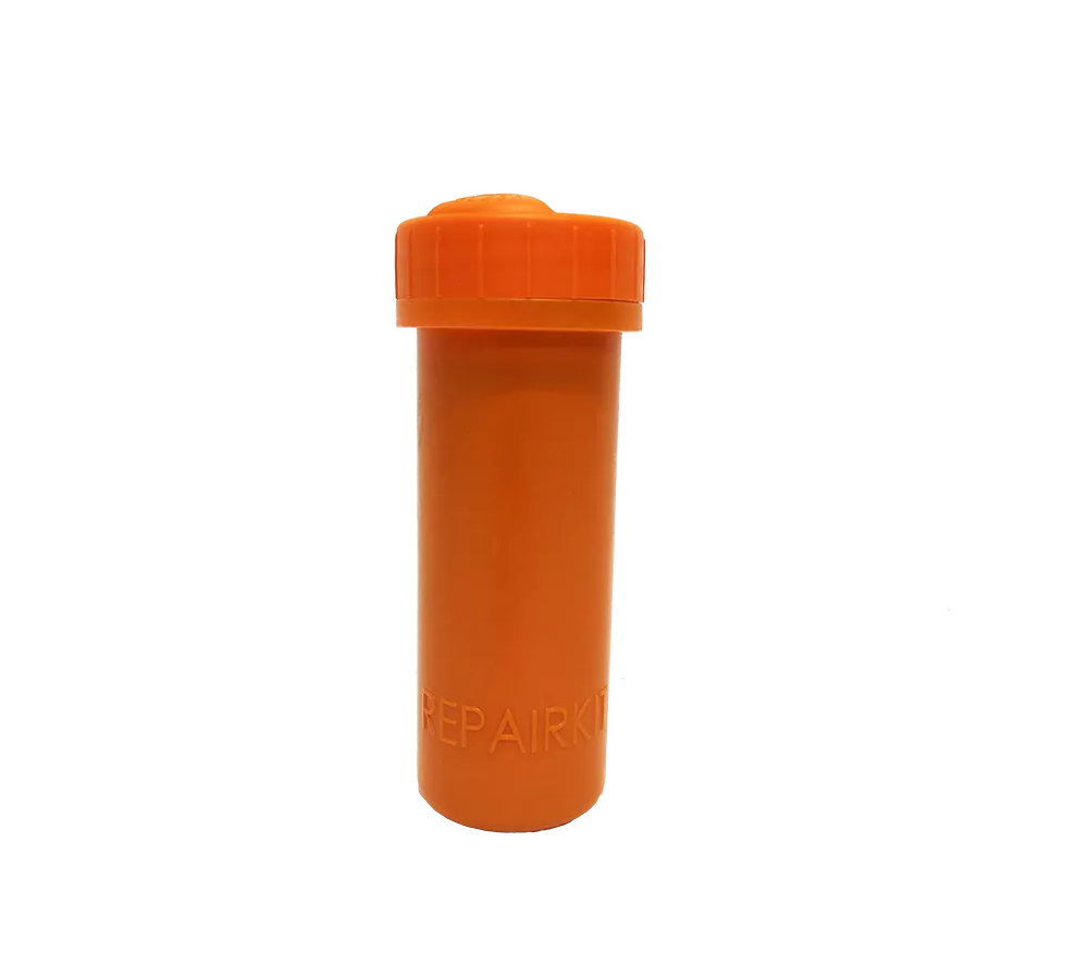 På billedet ses en lille, cylindrisk beholder i klart orange plastik med en skrue-låg øverst. Den enkle, robuste konstruktion og den tydelige farve gør den nem at finde i tasken eller værktøjskassen. Beholderen virker som en kompakt opbevaringsdåse til små reservedele, piller eller reparationssæt, og den indgraverede tekst antyder en funktion relateret til reparation eller vedligehold.