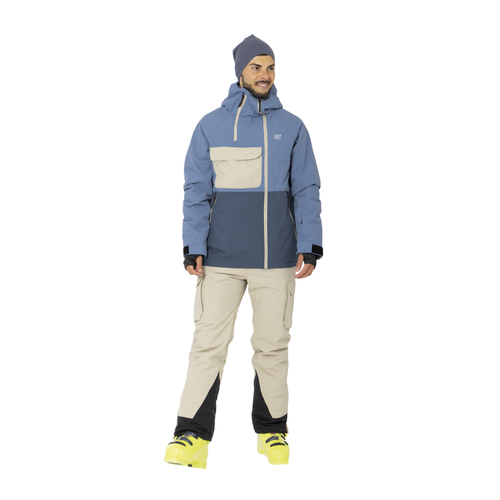 Denne herre skijakke fra 2117 of Sweden, model Krasse Padded, kombinerer stil og funktionalitet med sit moderne farvesammenspil i blå og beige. Den har en rummelig kængurulomme og tætsiddende manschetter, der sikrer, at kulden holdes ude, mens den justerbare hætte beskytter mod vind og vejr. Jakken er ideel til skituren eller som et vinterligt hverdagsstykke, der holder dig varm og tør gennem kulden.