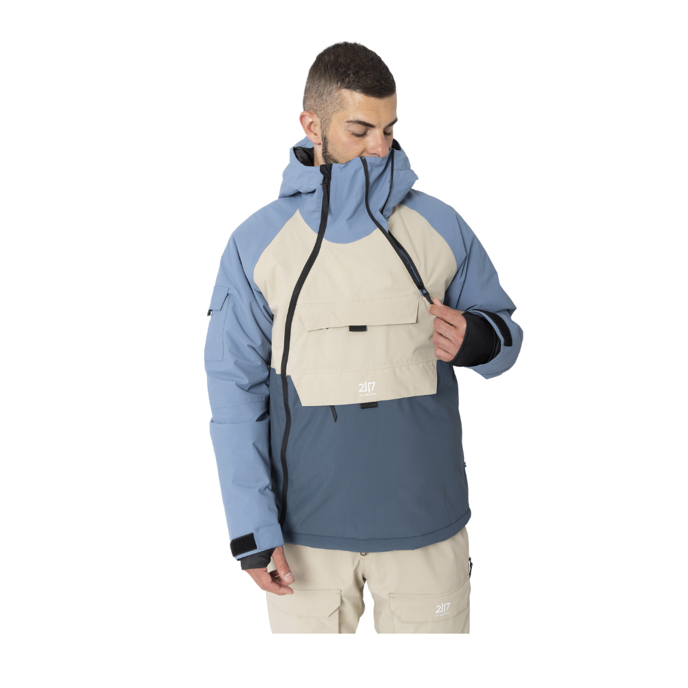 2117 of Sweden Nelkerim Padded Ski Anorak er en teknisk avanceret skijakke, der kombinerer funktionalitet og stilfuldt skandinavisk design i farverne blå og beige. Letforet med en kombination af uld og genanvendt polyester, tilbyder denne anorak optimal varme og åndbarhed, mens dens vandsøjletryk på 15.000mm sikrer tørhed selv under intens snefald. Jakken er udstyret med en fast hætte, integreret snefang og flere praktiske lommer, hvilket gør den ideel til aktive vinterdage.