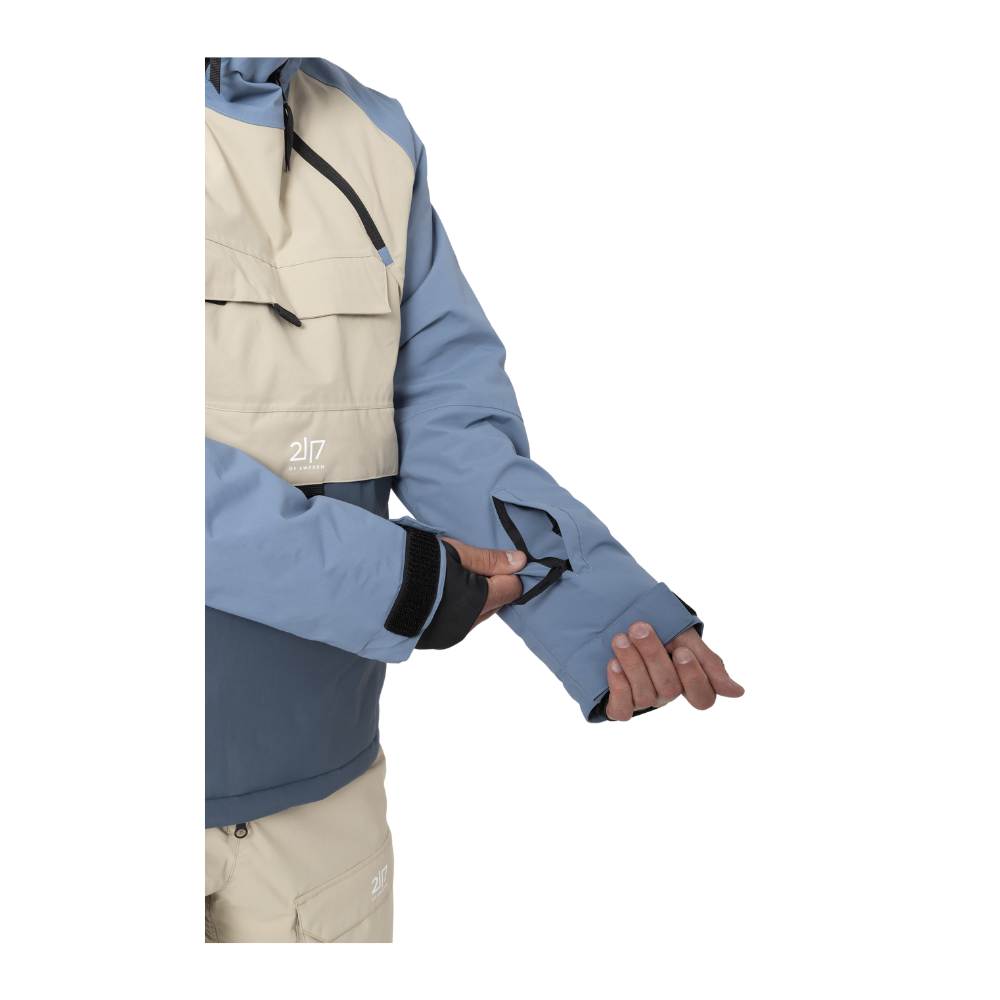 Denne skijakke fra 2117 of Sweden er designet til aktiv brug i sneen. "Nelkerim Padded Ski Anorak" kombinerer høj funktionalitet med holdbart materiale, der både er vand- og vindtæt takket være et vandsøjletryk på 15.000mm og en åndbarhed på ligeledes 15.000g/m2. Jakken har ALTO-uldvattering for optimal varme, mens den faste hætte og snefang sikrer beskyttelse mod elementerne. De forskellige lommer tilbyder praktisk opbevaring, hvilket gør denne jakke ideel til vinterens udfordringer.