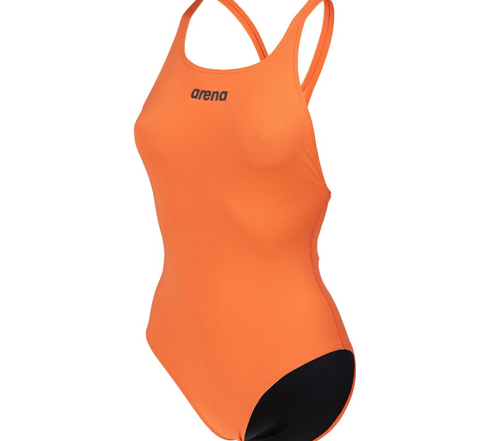 En enkelt, sporty badedragt i klar orange med minimalistisk design. Tynde skulderstropper og en åben ryg giver god bevægelsesfrihed, mens det slanke snit sidder tæt om kroppen. Et lille 'arena'-logo pryder brystet, og den sorte indvendige foring ved skridtet skaber kontrast. Ideel til træning eller konkurrence, hvor funktion møder et iøjnefaldende farvevalg.