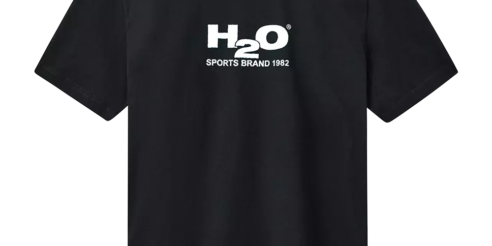 Sort T‑shirt i enkel, klassisk snit med rund hals og korte ærmer. På brystet er et hvidt logo med teksten "H2O" og underteksten "SPORTS BRAND 1982", som giver et sporty og minimalistisk udtryk. Trøjen fremstår som bomuldsbaseret, komfortabel og alsidig — velegnet til hverdag, træning eller som basislager i en afslappet garderobe. Enkel og tidløs stil præger designet.