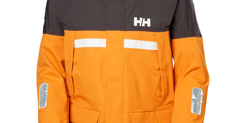 En vandtæt, isoleret skaljakke i kraftig orange med mørkegrå skulderpaneler og en aftagelig hætte med neonindlæg. Jakken har synlige reflekser på bryst og ærmer, rummelige frontlommer med låg og justerbare ærmekanter. HH-logoet pryder brystet. Designet kombinerer funktionalitet og synlighed, ideel til udendørs arbejde og aktiviteter i dårligt vejr, hvor både varme og sikkerhed er vigtige.