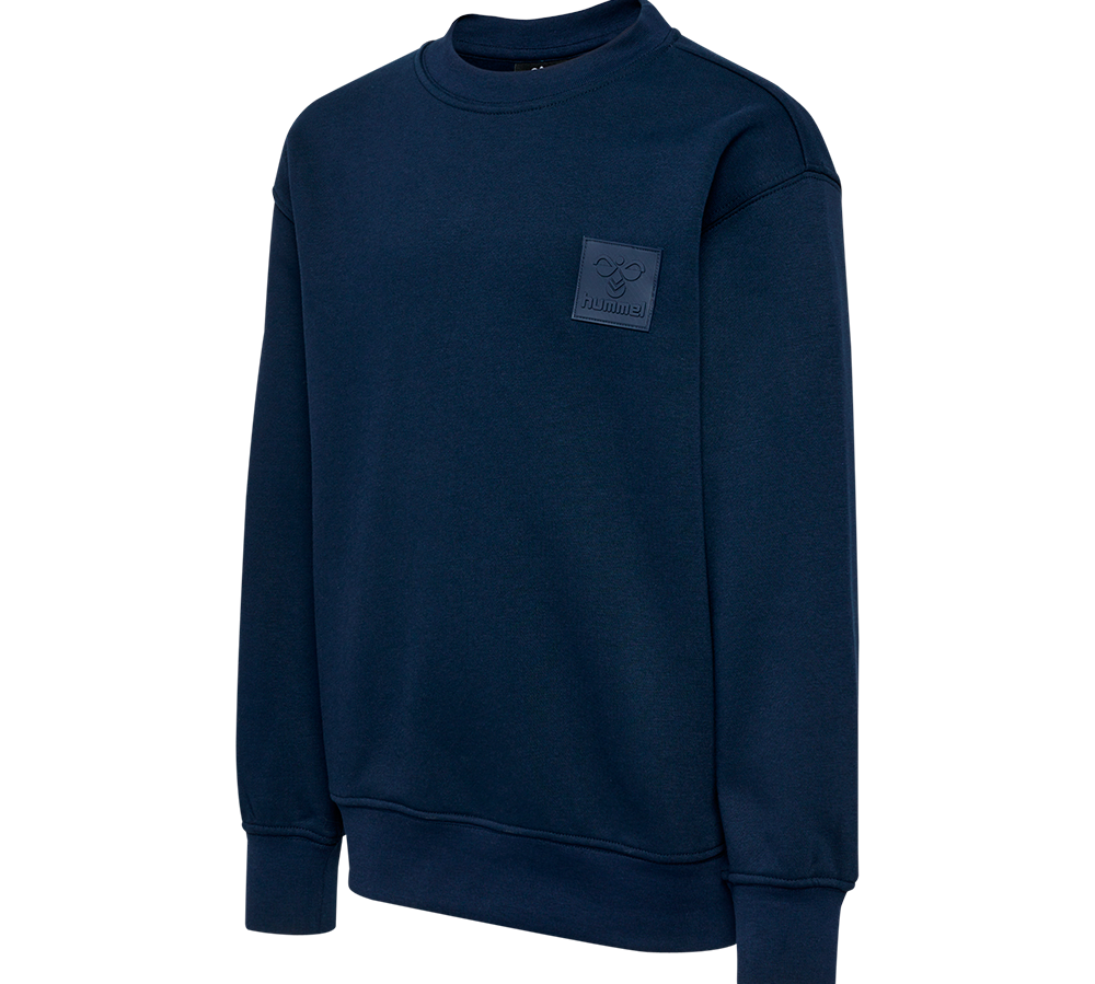 En enkel, mørkeblå crewneck-sweatshirt med rund hals og lange ærmer. Modellen har ribkanter ved ærmeafslutninger og i bunden for en tæt pasform, samt en diskret firkantet patch med logo på venstre bryst. Stoffet fremstår blødt og lidt kraftigt, ideelt til hverdagsbrug eller lag-på-lag. Designet er minimalistisk og tidløst, nemt at kombinere med jeans eller joggingbukser.