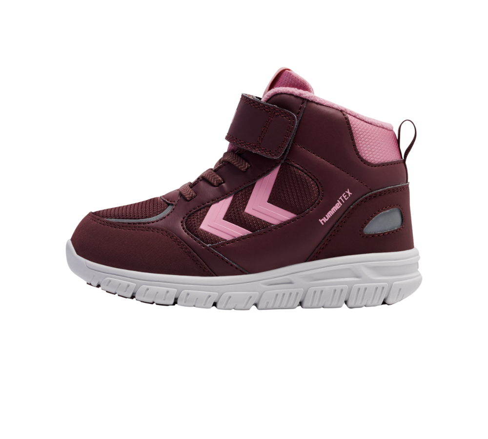 En børnesneaker i dyb burgunder med lyserøde detaljer, en hvid fleksibel gummisål og høj ankellukning. Skoen har velcrolukning øverst, snørelignende detaljer, meshpaneler for åndbarhed og en polstret krave for ekstra komfort. Siderne prydes af lyserøde chevrons og hummelTEX-logo, hvilket antyder vandafvisende egenskaber. Et praktisk design til aktive børn, der kombinerer støtte, komfort og synlighed.