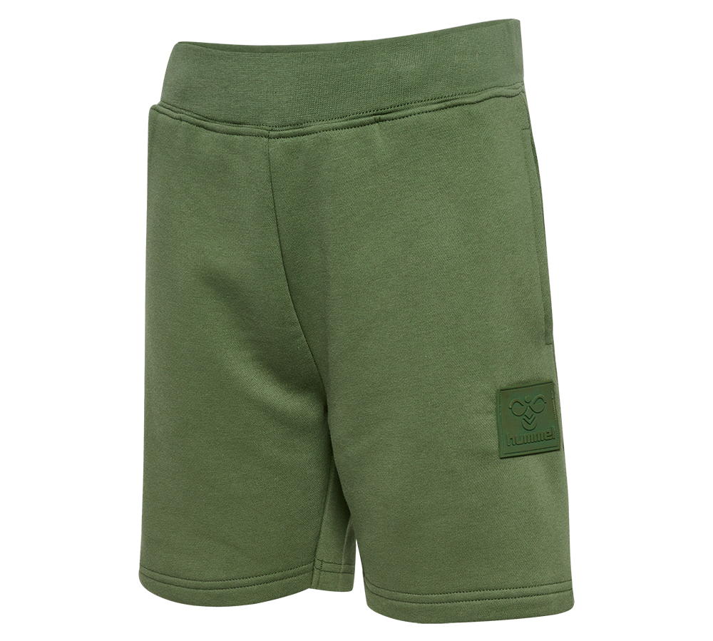 Enkle, olivengrønne sweatshorts med bred elastisk talje og blød, børstet inderside. Knælange, komfortable snit med rene syninger og diskret gummipatch med hummel-logo på låret. Fremstillet i en kraftig bomuldsblanding, velegnet til hverdag, afslapning og let træning. Minimalistisk design uden synlige lommer giver et strømlinet udtryk og let bevægelsesfrihed. Nem at style med t-shirt eller hoodie.