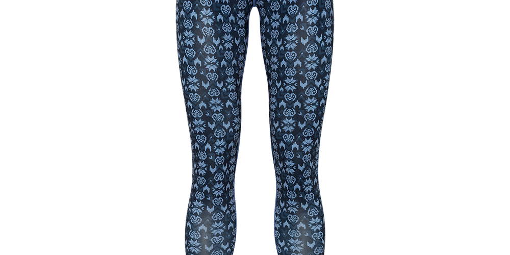 Et par tætsiddende leggings i mørkeblå med et gentaget lyseblåt blomster- og ornamentmønster, der dækker hele længden. De er lange til anklerne og har en kontrastfarvet, pastelrosa elastik i taljen, som giver et feminint touch. Materialet virker elastisk og funktionelt, ideelt som trænings- eller termounderlag. Designet fremstår slankt og anatomisk med flade syninger for komfort.