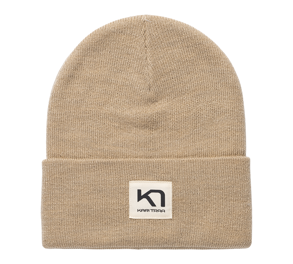 Beige strikhue med foldet kant og enkelt, tidløst udtryk. Huen er lavet i tæt, blødt strik med jævn struktur og en lille firkantet label foran med logoet "Kari Traa". Den neutrale farve og rene silhuet gør den let at style til både hverdag og friluftsliv, og den foldede kant giver ekstra varme omkring ørerne. Et praktisk og stilrent vintertilbehør.