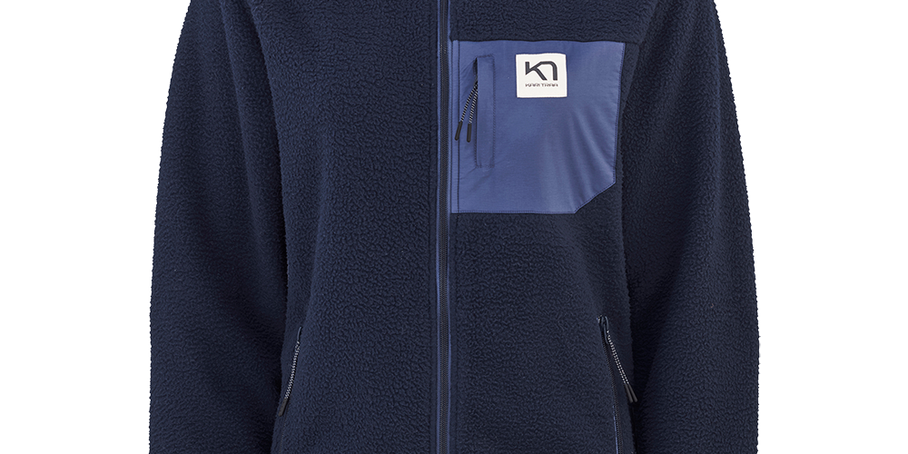 En mørkeblå fleecejakke med lynlås og høj krave, lavet i blød, pelslignende polarfleece, der holder på varmen. Jakken har kontrastfarvet brystlomme med lynlås og lille logo, samt to sidelommer med lynlås. Ribkanter ved ærmerne med diskret stribe giver et sporty finish. Enkel og funktionel i snittet, velegnet til hverdag og udendørsaktiviteter på kølige dage.