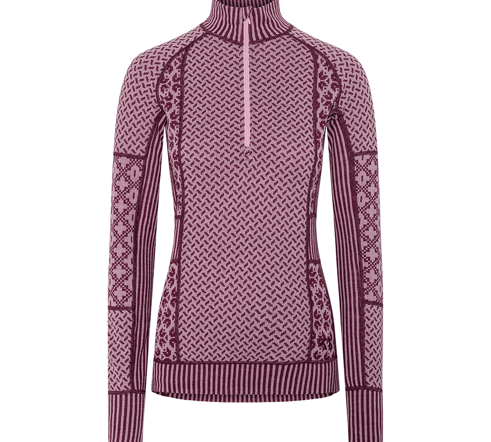 Langærmet, figursyet strikbluse med høj krave og halv lynlås. Mønstret i nuancer af lyserød og vinrød med gentagne geometriske motiver, striber ved kanter og varierede strikketeknikker. Ribstrik ved ærmer, krave og kant, dekorative paneler langs siderne og ærmerne. Udførelsen giver et varmt, hyggeligt udtryk — velegnet som lag-på-lag til koldt vejr eller som et stilfuldt hverdagsplagg.