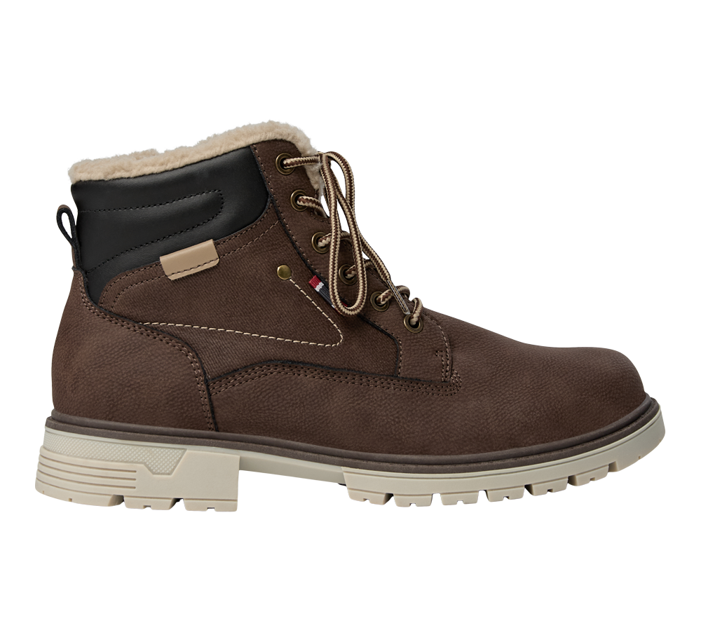 Brun vandrestøvle i robust, nubuck-lignende materiale med beige gummisål og skridsikkert mønster. Støvlen har polstret fodledsdel i sort og varm, beige pelsforing indvendigt. Runde snørebånd føres gennem metaløjer og forstærkede syninger, mens en lille træksløjfe bagtil gør den nem at tage på. Designet kombinerer funktionalitet og afslappet stil til kolde dage.