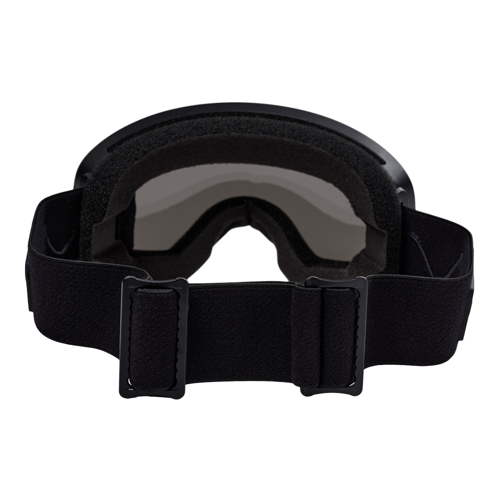 Denne billede viser Nanok Goggle 25, en moderne skibrille designet til voksne. Brillerne har et stort, buet uni-linse design, der sikrer bred visuel klarhed og beskyttelse. Rammen er strømlinet og minimalistisk, understøttet af en justerbar, elastisk rem med Nanoks logo, der sikrer en sikker og komfortabel pasform. Farven er en neutral, mørkegrå, der nemt kan matches med forskelligt skiudstyr. Perfekt til både amatører og erfarne skiløbere, der søger kvalitetsudstyr til deres vintersportseventyr.