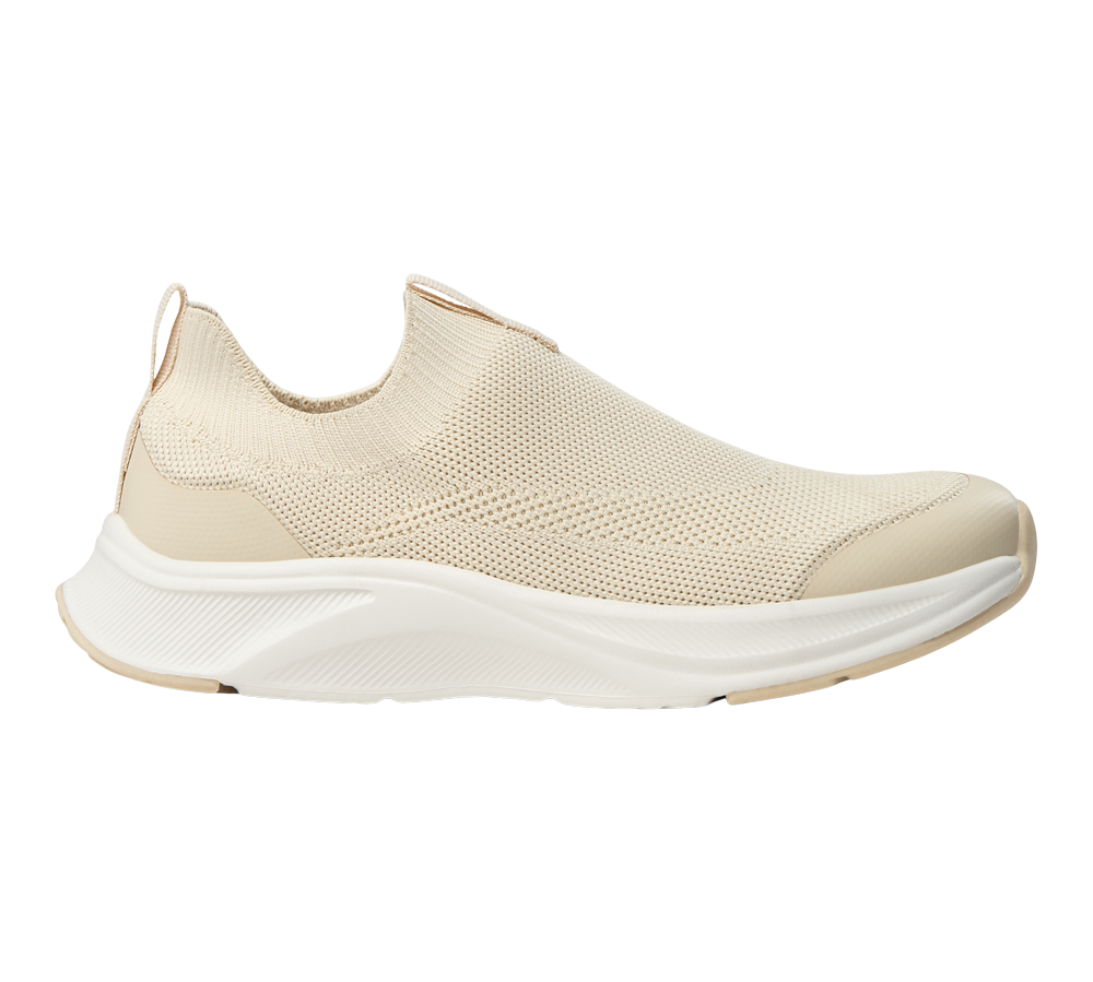 En elegant, lysebeige slip-on-sneaker med strikket overdel og blødt, polstret skaft. Skoen har en åndbar, tekstureret overflade, forstærket tå og en kraftig, hvid EVA-sål med let buet profil for støddæmpning. Minimalistisk design, elastisk pasform og bageste trækflap gør den nem at tage på. Velegnet til hverdagsbrug, gåture og afslappede outfits. Den neutrale farve passer til mange stilarter.