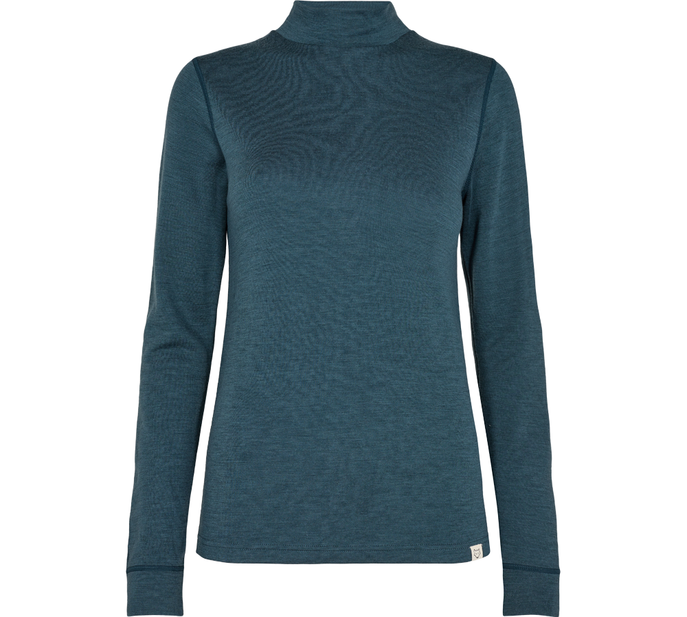 En enkel, tætsiddende højhalset bluse i dyb petrolblå med lange ærmer. Stoffet virker som en fin, let strik eller merinould med en glat overflade, der lægger sig nært kroppen. Designet er minimalistisk med rene sømme og en lille logoetiket ved faldet. Blusen er alsidig til både lag-på-lag og enkel styling, ideel til hverdag eller som basis i garderoben.