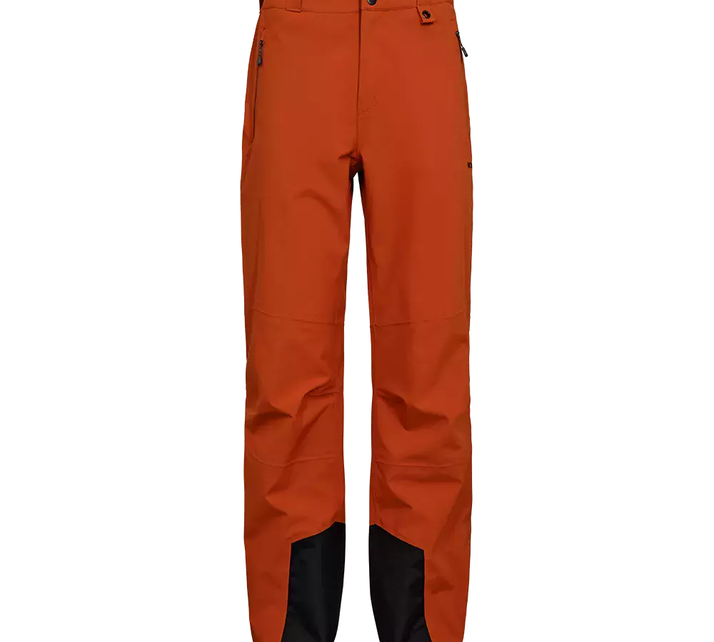 Disse orange fritidsbukser har et teknisk, robust udtryk med lige ben og forstærkede sorte bundstykker ved anklerne. I taljen ses bæltestropper og to trykknapper, og sidelommer med lynlås giver funktionel opbevaring. Bukserne virker designet til udendørsaktiviteter med let artikulerede knæ og slidstærke syninger, hvilket giver et praktisk og stilrent look til aktive dage i naturen.