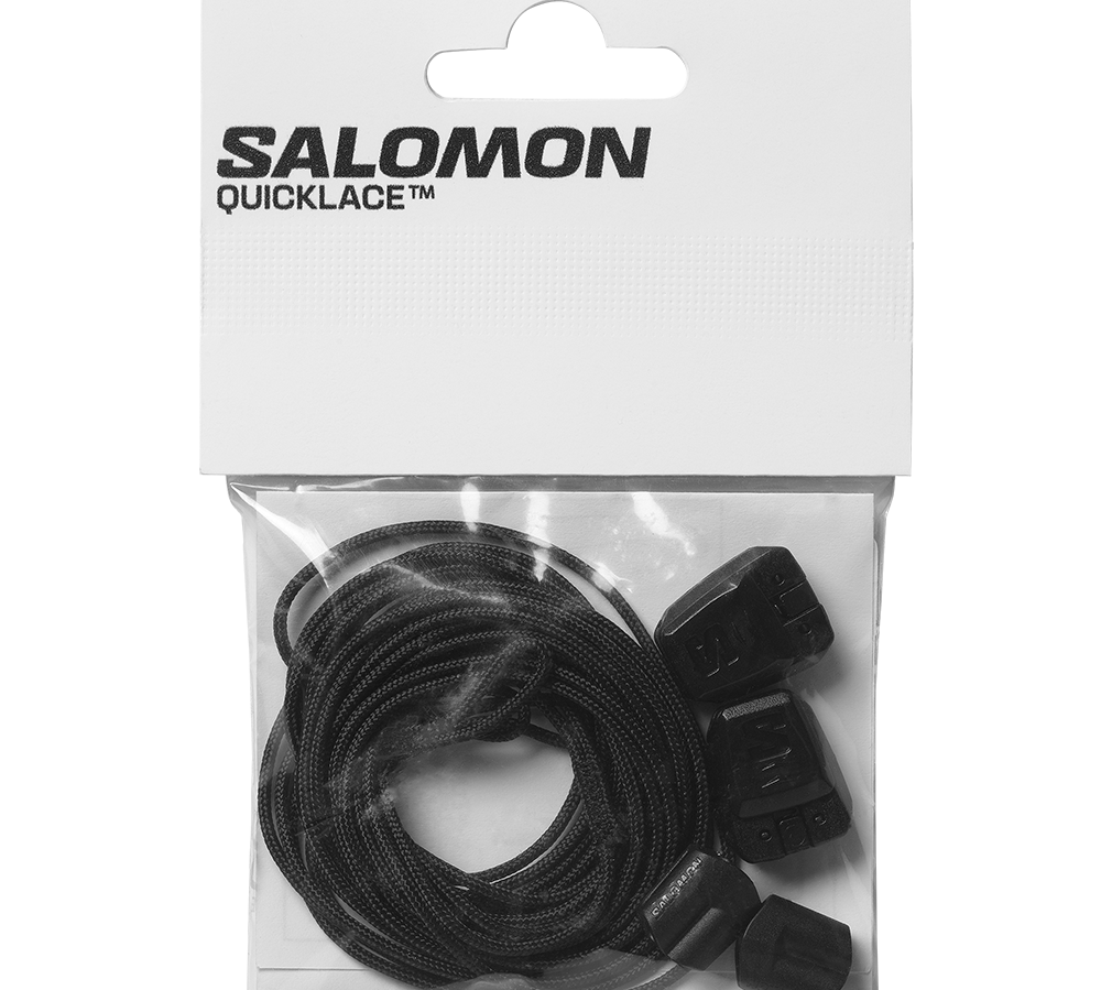 Billedet viser et sæt Salomon Quicklace snørebånd i original emballage. Et par tynde, sorte elastiske snørebånd er fint rullet sammen i en klar plastpose, ledsaget af små sorte låse og endestykker til hurtig indstramning. Designet signalerer praktisk funktionalitet til løbe- og vandresko med fokus på enkel, sikker lukning og nem udskiftning.
