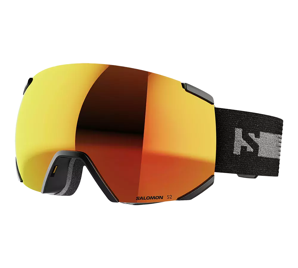 Salomon S2-skibriller med stor, sfærisk linse i varm orange- og kobberrefleksion, der dækker ansigtet bredt for maksimal udsyn. Rammen er sort og diskret, med blød skumforing ved næsen og en bred, elastisk rem i sort med logo. Brillerne giver et stilrent, teknisk udtryk og er velegnede til alpin skiløb og snowboard, hvor kontrast og beskyttelse mod sol og sne er vigtig.