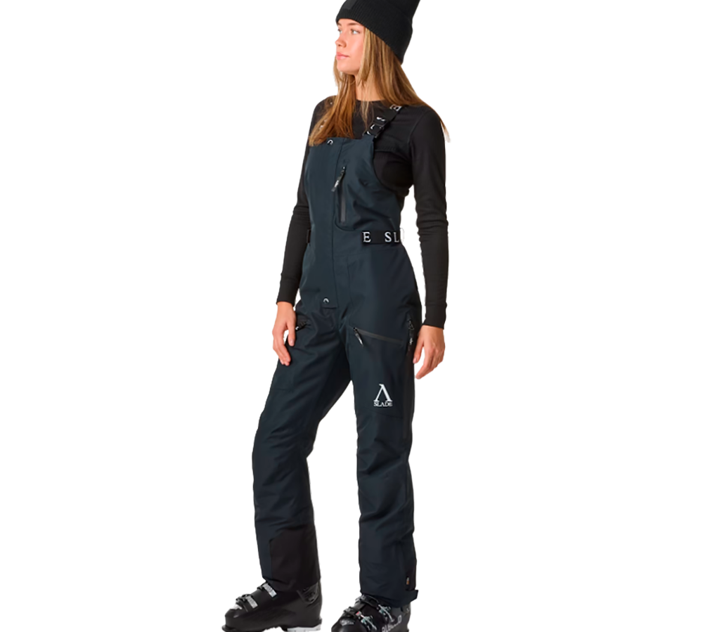 Denne model bærer Slade Aspen Bib Pants W skibukser, der er ideelle til skituren. Disse bukser er designet til at tilbyde en overlegen kombination af stil og funktionalitet med en vandtæt og åndbar konstruktion. De har høj talje, justerbare seler og masser af praktiske lommer, hvilket gør dem både flatterende og funktionelle på skiløjperne. Selerne og de diskrete logoer tilføjer et moderne twist til det klassiske skitøj.