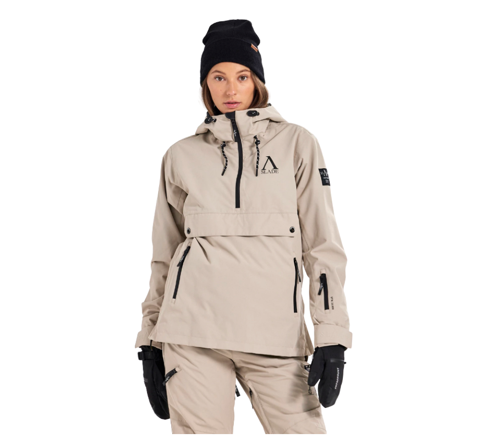 Denne billede viser en kvinde klædt i Slade Aspen Anorak W, en anorak designet specifikt til damer. Hun er iført en neutralt farvet jakke med flere funktionelle detaljer som rummelige lommer og justerbare snore. Jakken bærer Slade-logoet tydeligt på brystet, hvilket understreger brandets identitet. Anorakken ser både stilfuld og praktisk ud, velegnet til udendørs aktiviteter i kølige klimaer.