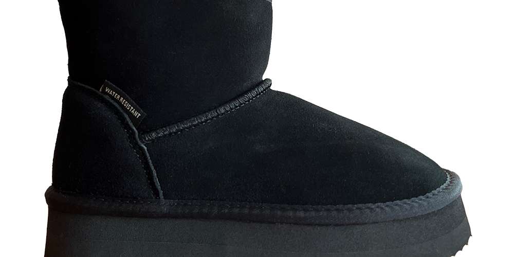 Sort kort vinterstøvle i ruskindslignende materiale med rund tå og kraftig, profileret sål. Støvlen har lav hælkappe, diskret syning langs overgangen og et lille "water resistant"-mærke ved skaftet. Indeni skimtes en blød foring, hvilket lover varme og komfort. Farven er dyb sort og passer nemt til både jeans og vinterfrakker.