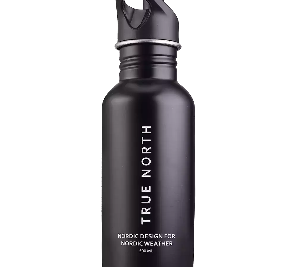 En elegant, mat sort drikkeflaske i metal med praktisk skruelåg og bøjle til nem transport. Flaskens lodrette tekst "TRUE NORTH" og underskrift "Nordic design for Nordic weather 500 ml" understreger det nordiske, funktionelle udtryk. Den enkle, robuste konstruktion virker ideel til udendørs aktiviteter og daglig brug, hvor både stil og holdbarhed vægtes højt.