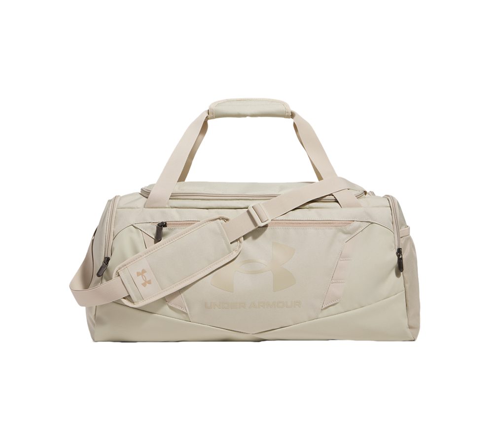 En beige duffel-taske i robust polyester med klare linjer og minimalistisk design. Den har både håndtag og justerbar skulderrem med polstret skulderstykke, lynlåslommer foran og i siden samt rummelig hovedåbning. Et diskret logo præger fronten. Tasken virker velegnet til træning, weekendture eller som rejsetaske takket være praktiske lommer og solid konstruktion.