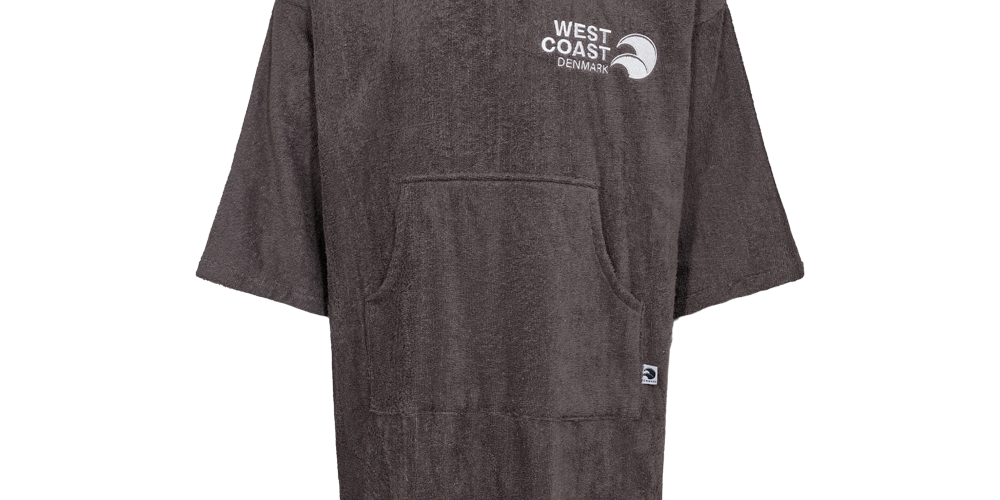 Denne billedvisning fremhæver en "West Coast Denmark Poncho LS 25", en voksen badekåbe fra West Coast Denmark. Kåben præsenteres i en neutral grå farve med en diskret logo på brystet, som afspejler elegance og diskretion. Med en komfortabel hætte og rummelige lommer er denne badekåbe både praktisk og stilfuld, ideel til afslapning ved stranden eller derhjemme. Det tykke stof sikrer varme og komfort efter et bad eller en svømmetur.